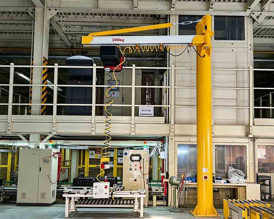 Aluminum jib crane installed at industrial workstation for load handling Aluminum jib crane installed at industrial workstation for load handling